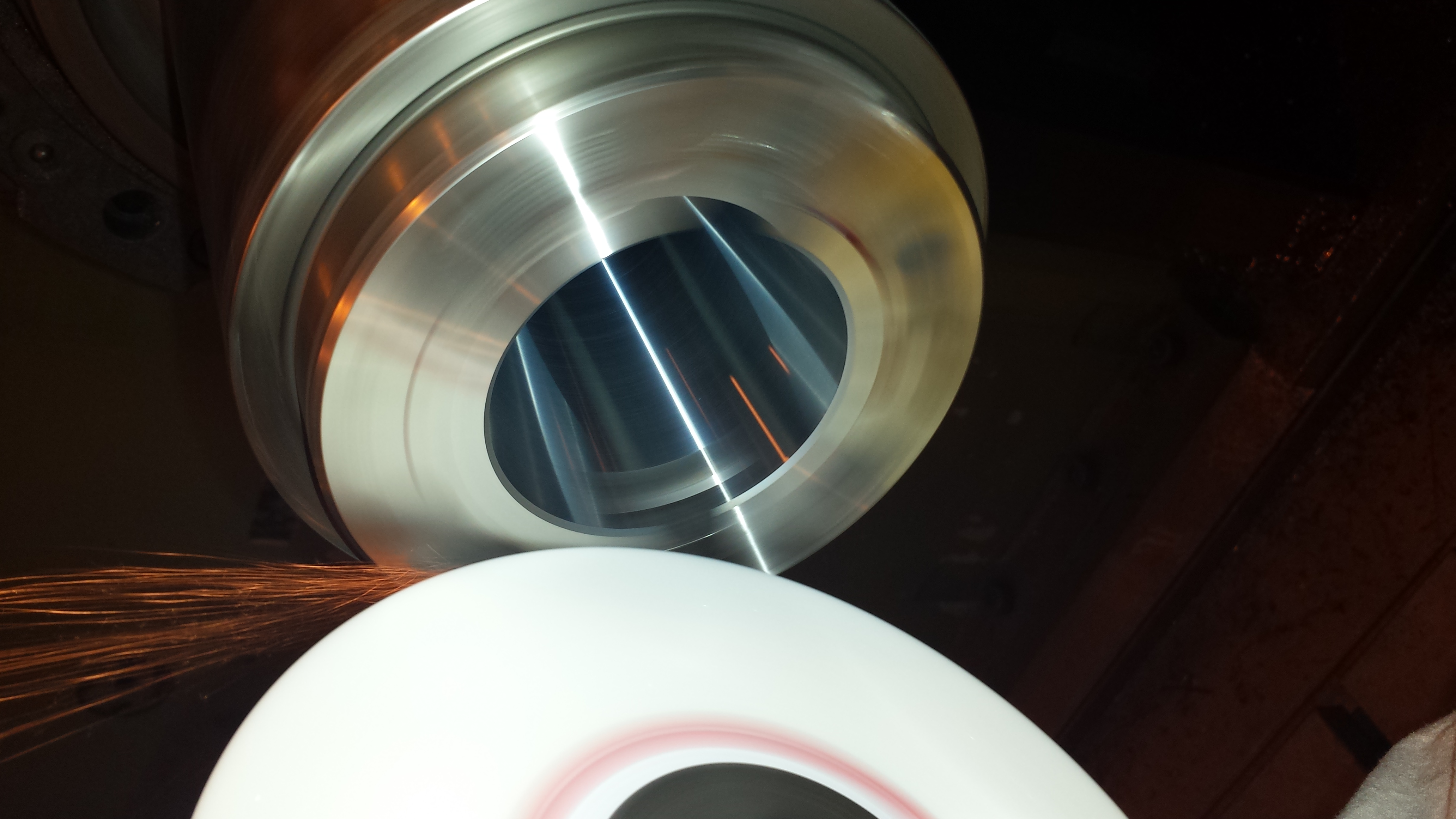 A precision grinding wheel finishing the face of a machine-tool spindle.